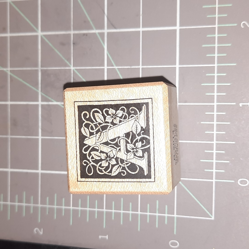 A Monogram rubber stamp square with floral vine